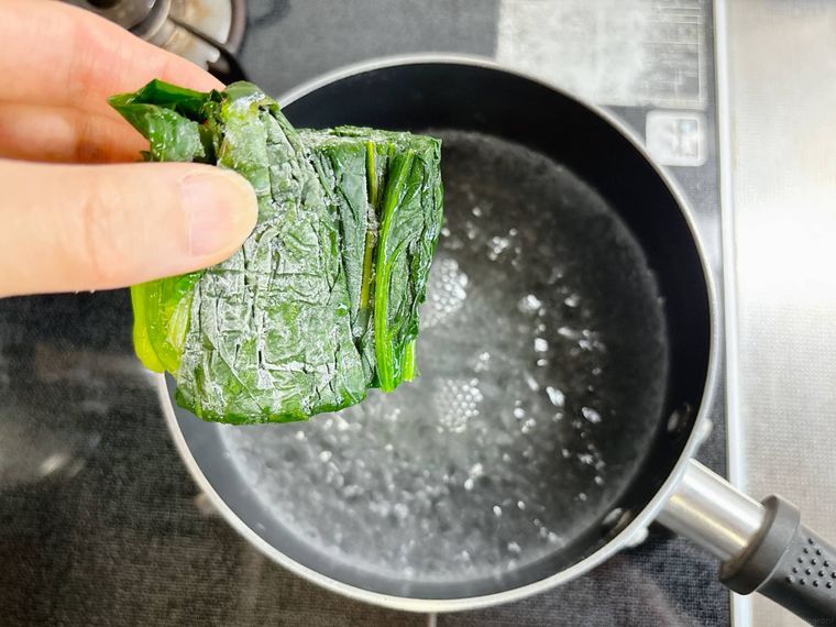 ほうれん草を凍ったまま鍋に入れる様子