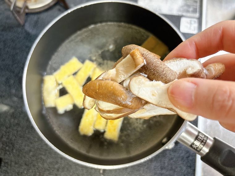 冷凍しいたけをだし汁に入れる様子