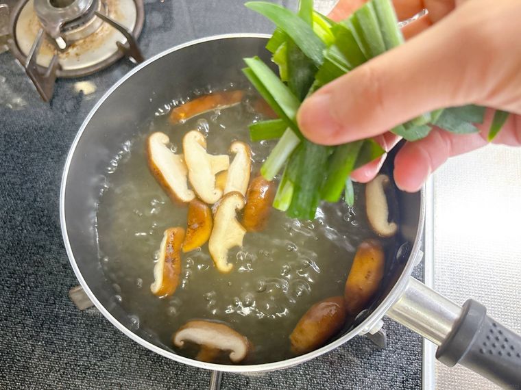 ニラを凍ったまま汁物に入れる様子