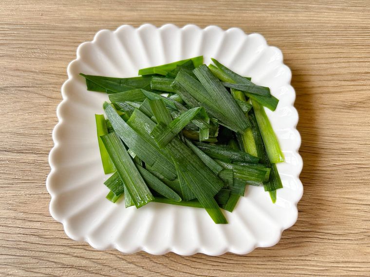 白色の皿におかれた解凍したニラ