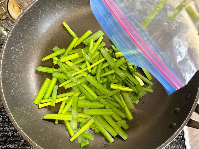 冷凍したニラをフライパンで炒める様子