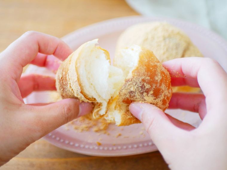 きな粉揚げパンを両手にもって、食べる様子