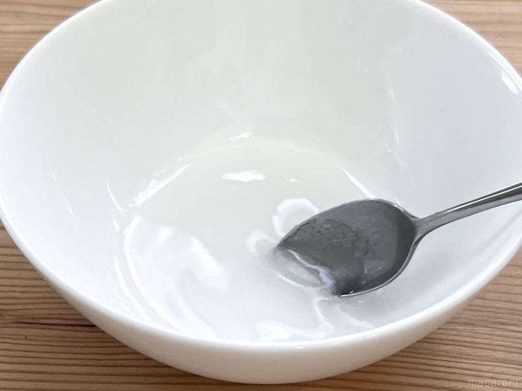 グラニュー糖と水をスプーンで混ぜ合わせている様子