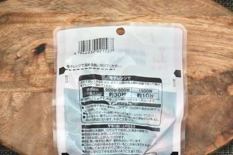 木のカッティングボードにのったおつまみのパウチ