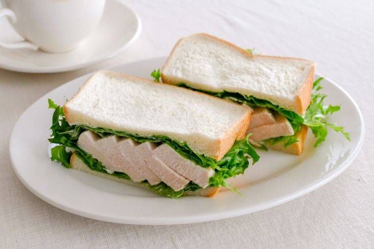 白色の皿に盛られたサラダチキンのシンプルサンドイッチ