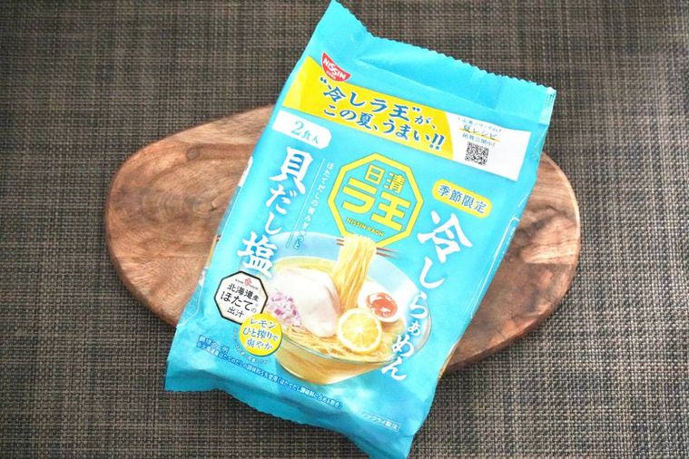 木のカッティングボードにのった冷やしラーメンの水色のパッケージ