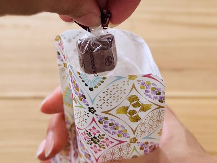 デザインペーパーとジップ付き袋で作ったラッピング袋にチョコレートを入れている様子