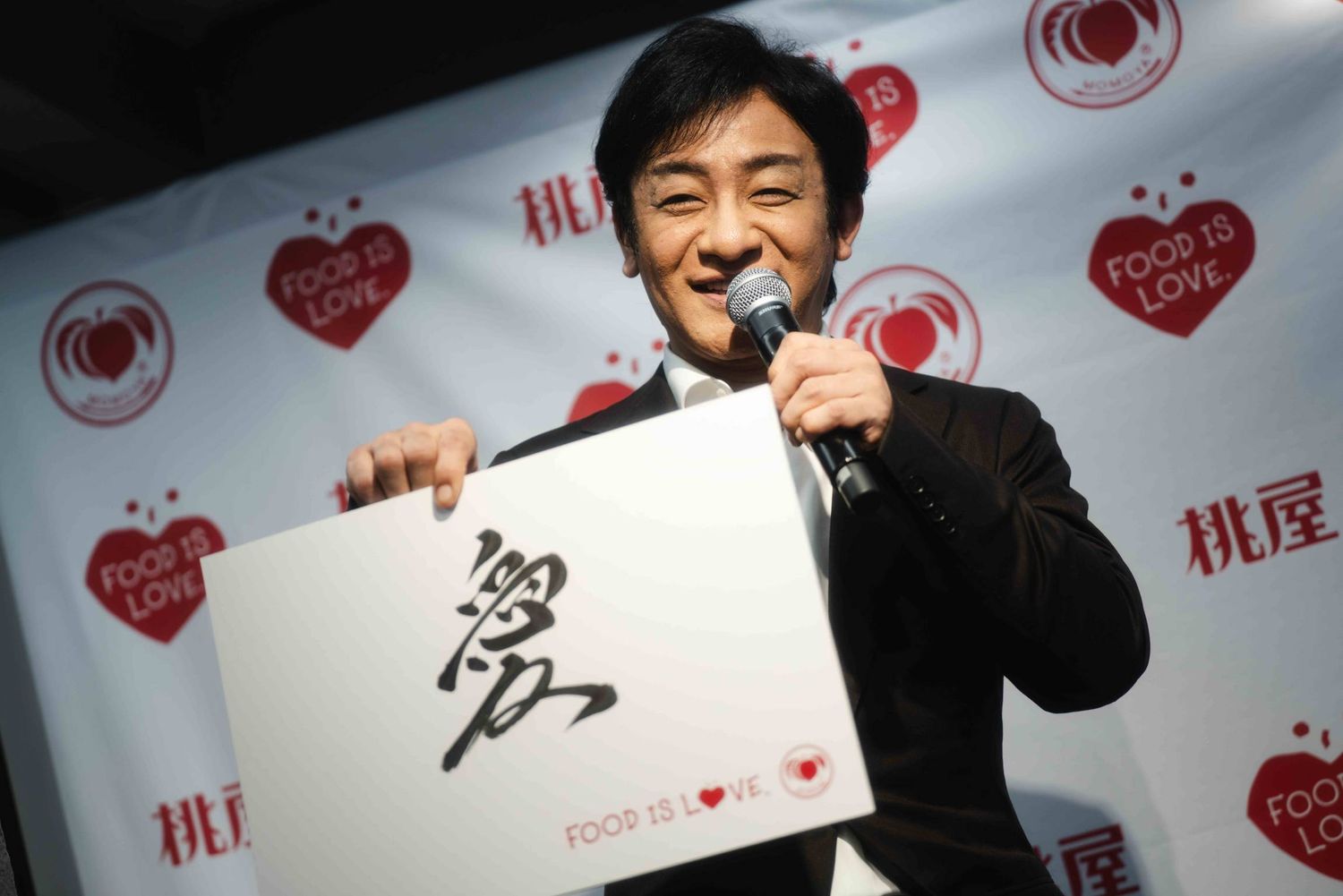 愛というフリップを掲げる男性