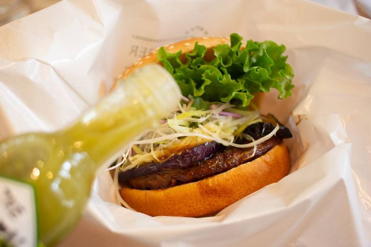 フレッシュネスバーガー柚子胡椒香る 香味野菜の照り焼きバーガーにゆずすこを振りかけている様子