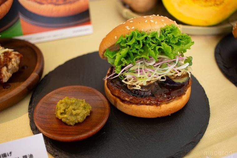 フレッシュネスバーガー柚子胡椒香る 香味野菜の照り焼きバーガーと柚子胡椒が黒いプレートの上に並んでいる