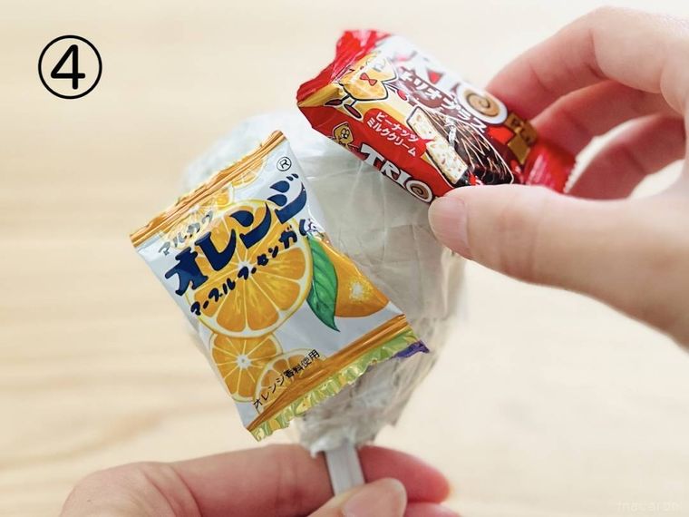 丸めた紙にお菓子を貼り付けている様子