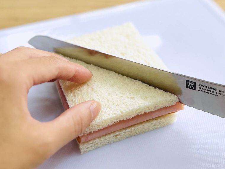 ハム卵サンドを包丁で切っている様子