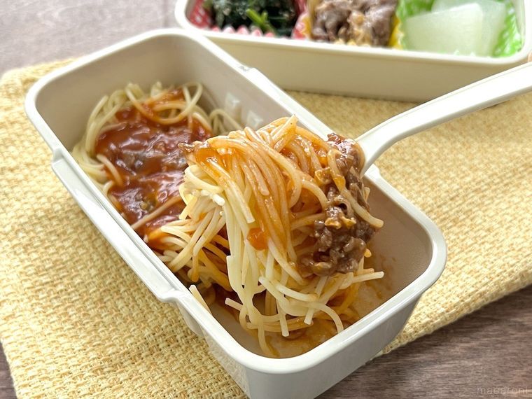 麺が固まったミートソースパスタをフォークで持ち上げている様子