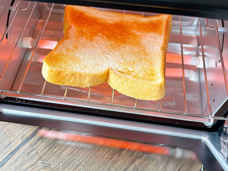 トースターを開けて食パンの焼き色を見る様子