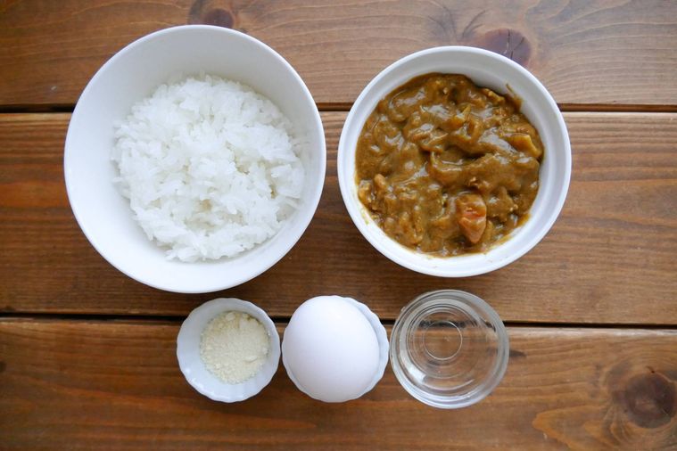 卵チーズカレーチャーハンの材料が並ぶ木製テーブル