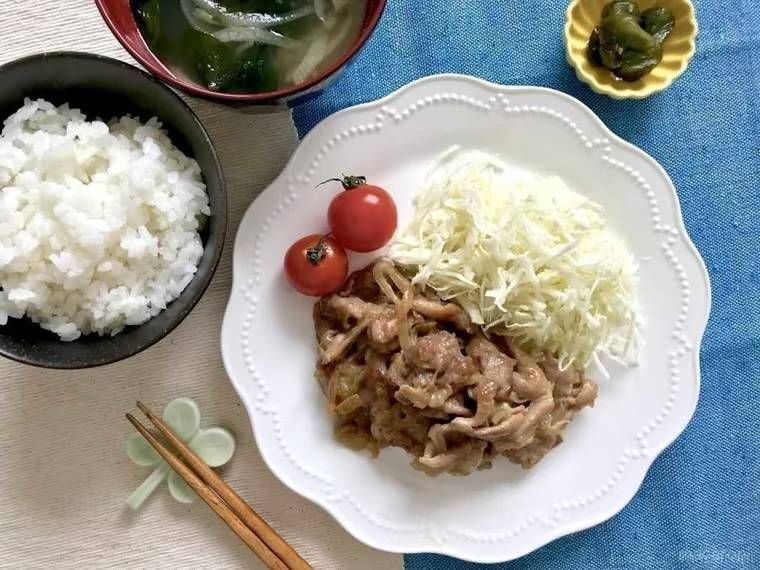 食卓にしょうが焼き、ごはん、味噌汁が並べられている様子
