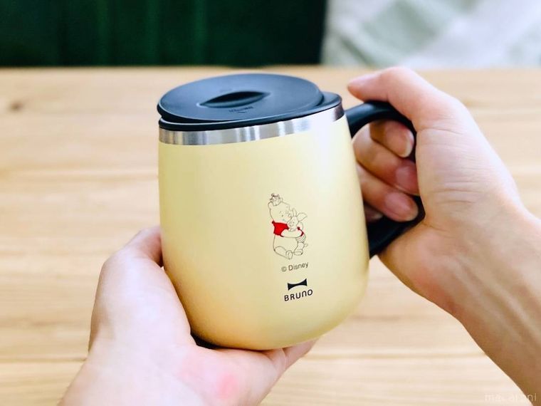Pooh 蓋つきステンレスマグを手で持っている様子