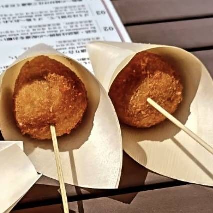 串に刺さった、まんまるの形がかわいらしい深川コロッケ