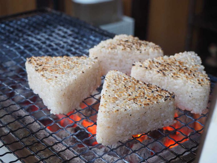 七輪の上で焼き色がついた4個のおにぎり