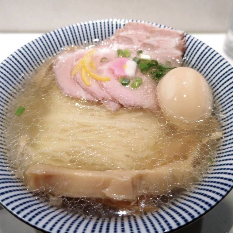 ストライプの器に盛られたチャーシューと卵ののった鯛塩ラーメン