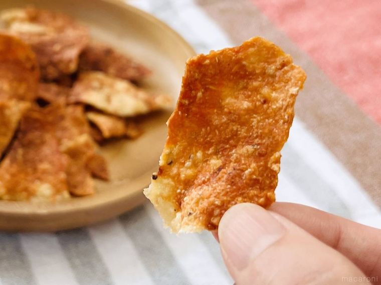 鶏ひき肉で作ったポテトチップス風スナックを指でつまんだ様子