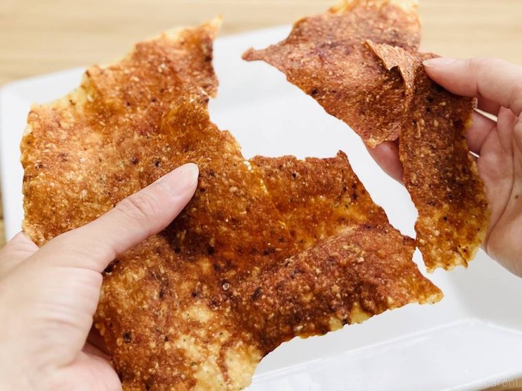 鶏ひき肉で作ったポテトチップス風スナックを手で割っている様子