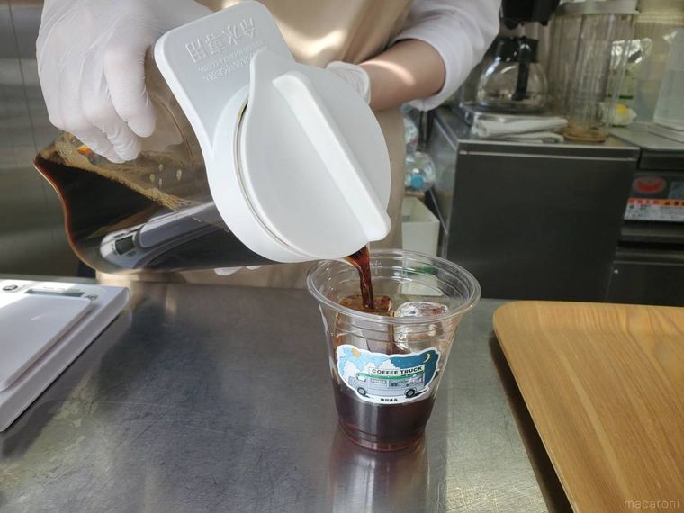 スタッフが無印良品カフェインレスコーヒー ICEDを注いでいる様子