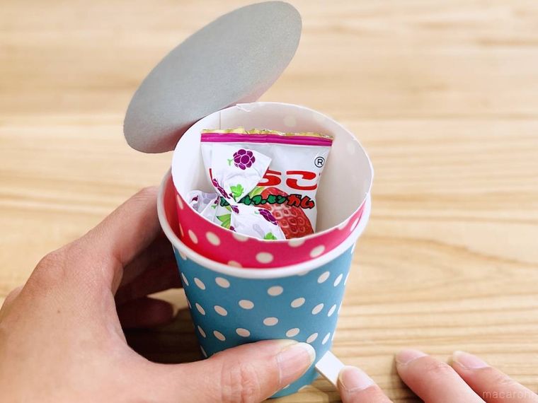 紙コップで作ったペダル式ゴミ箱にお菓子を入れた様子