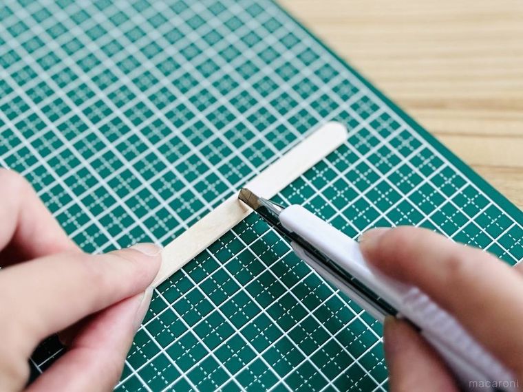 アイスの棒にカッターで切り込みを入れている様子