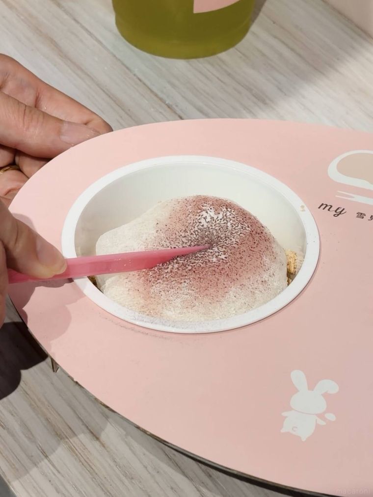 ピンクのパウダーがかかった雪見だいふくにピックを入れる様子