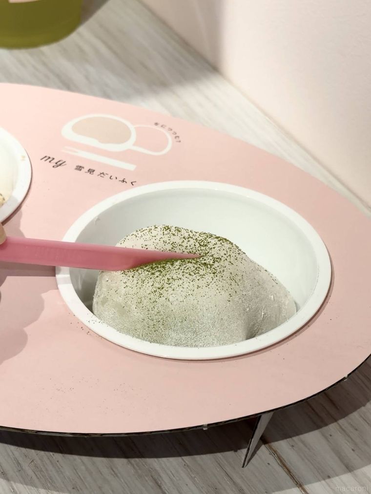 抹茶パウダーのかかった雪見だいふくにピックを入れる様子
