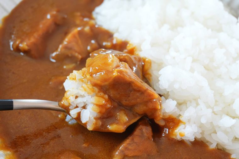 カレーとごはんをスプーンですくっている
