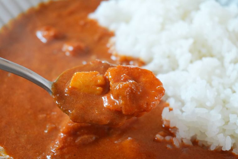 シーフードカレーをすくっている