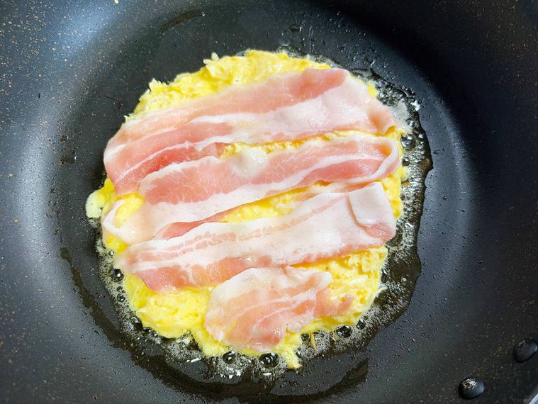 お好み焼きをフライパンで焼く様子