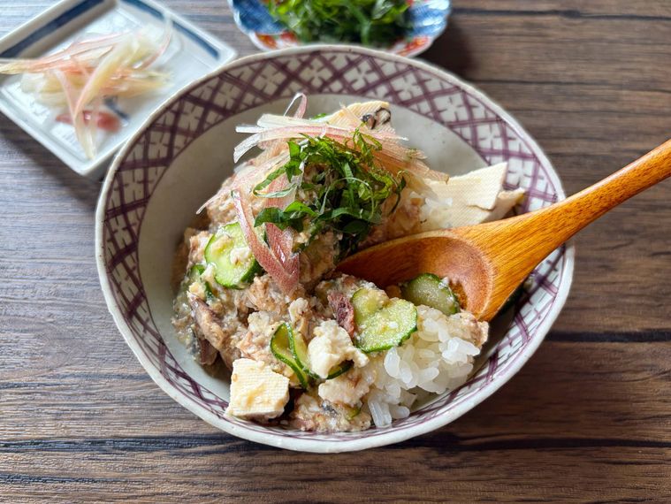 冷や汁にごはんを少しずつ浸して食べる様子