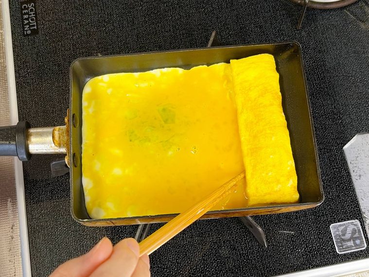 巻いた卵の下にも卵液を流す様子