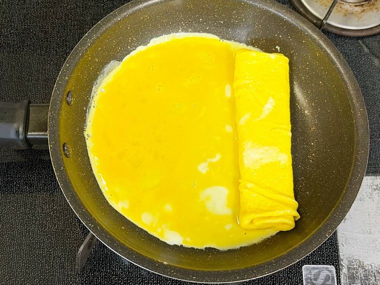 丸いフライパンで卵焼きを焼く様子