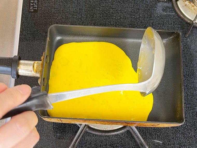 卵焼き器に卵液を流す様子