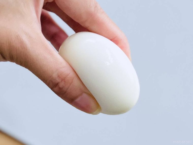 ゆで卵を指でつぶしている様子
