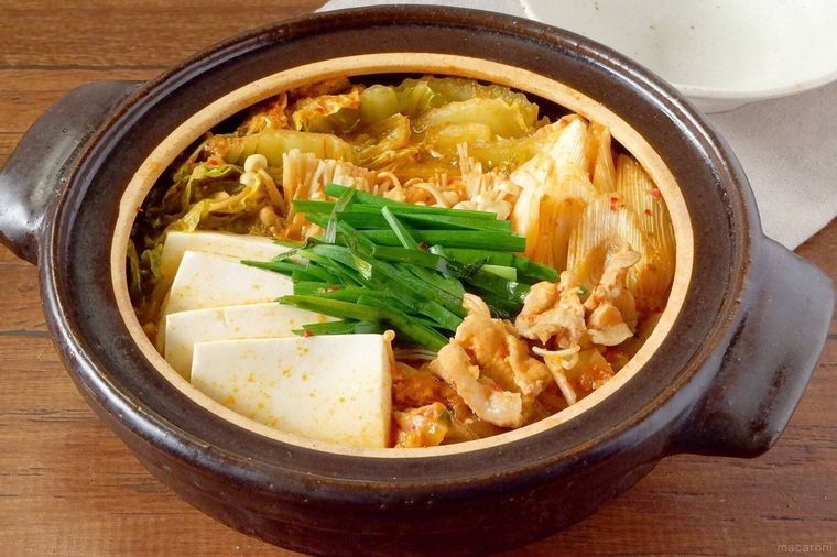 茶色の土鍋に入ったキムチ鍋と白色の取り皿