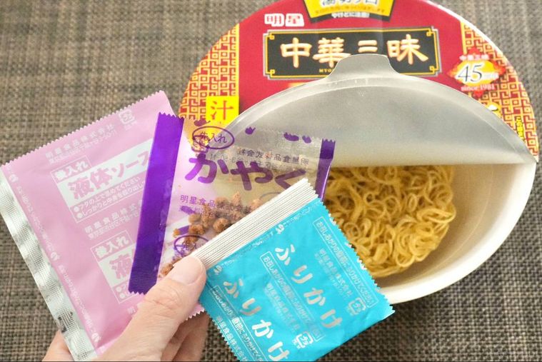 カップ麺からソースやかやくを取り出す様子
