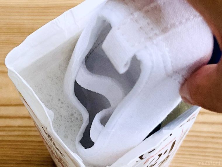 ぬるま湯と洗剤が入った牛乳パックに上履きを入れている様子