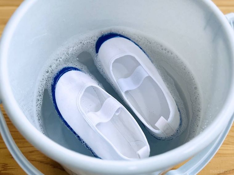 水と洗剤が入ったバケツに上履きを入れた様子