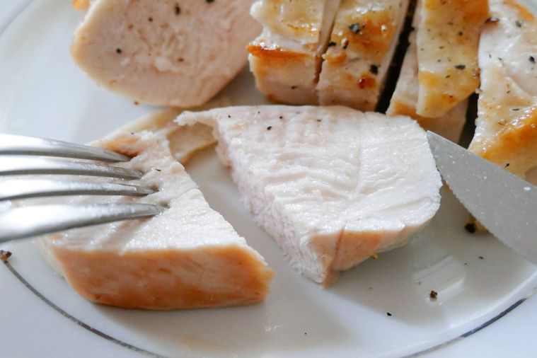 塩糖水に浸けた鶏むね肉ソテーをナイフとフォークで切った様子