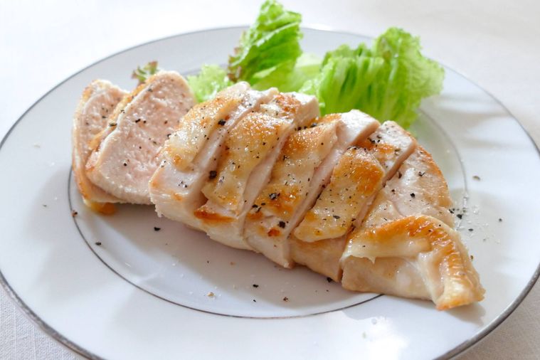 カットした鶏むね肉のソテーとレタスを盛り付けた皿
