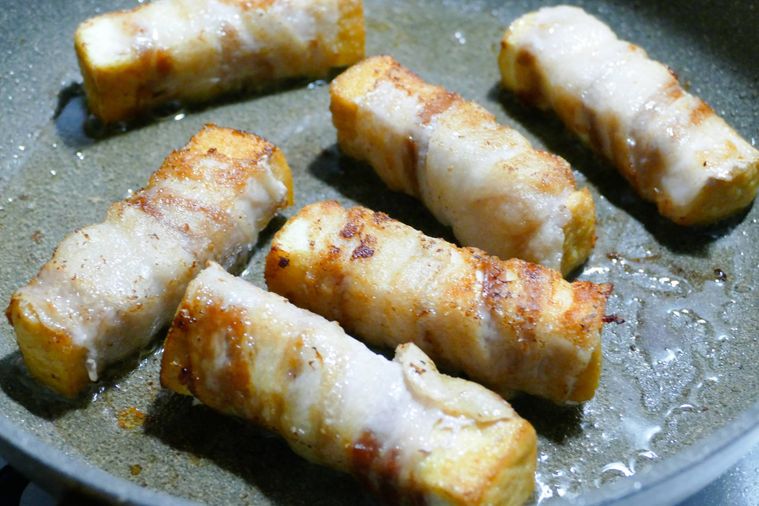 厚揚げの豚バラ巻きをフライパンで焼く様子