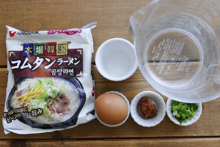 卵雑炊風コムタンラーメンの材料が並ぶ木製テーブル