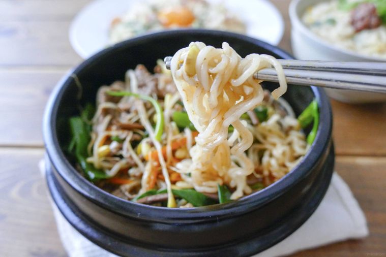 ユッケジャン風コムタンラーメンを箸で持ち上げる様子
