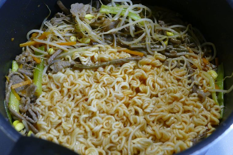 鍋に水と麺、粉末スープを入れて煮込む様子