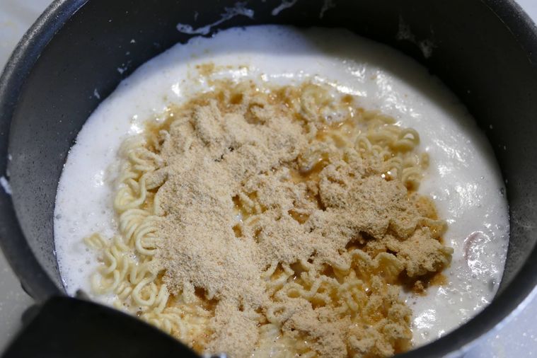 水と牛乳を煮立たせた鍋に、麺と粉末スープを加えた様子